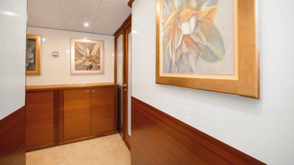 Various paintings with flowers are framed in silver or gold and hang in the hallway.